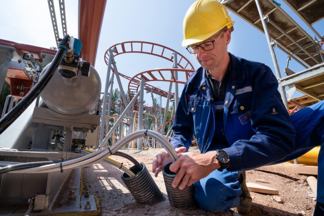 A construction worker is cabling a roller coaster with LAPP cables