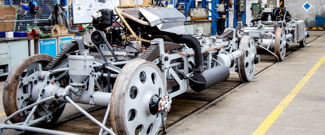 Auf dem Bild sieht man das offene Fahrwerk vom historischen Zug „Slowakischer Pfeil“ in der Werkshalle.