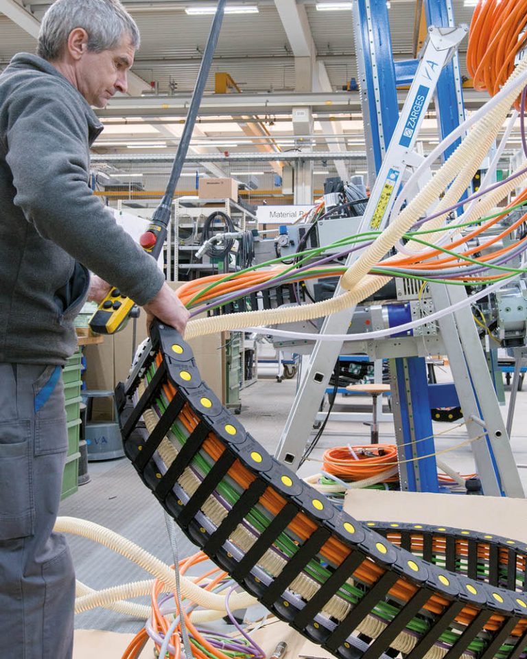 Ein Mitarbeiter von Bystronic glass packt eine SILVYN® CHAIN Energieführungskette von LAPP aus.