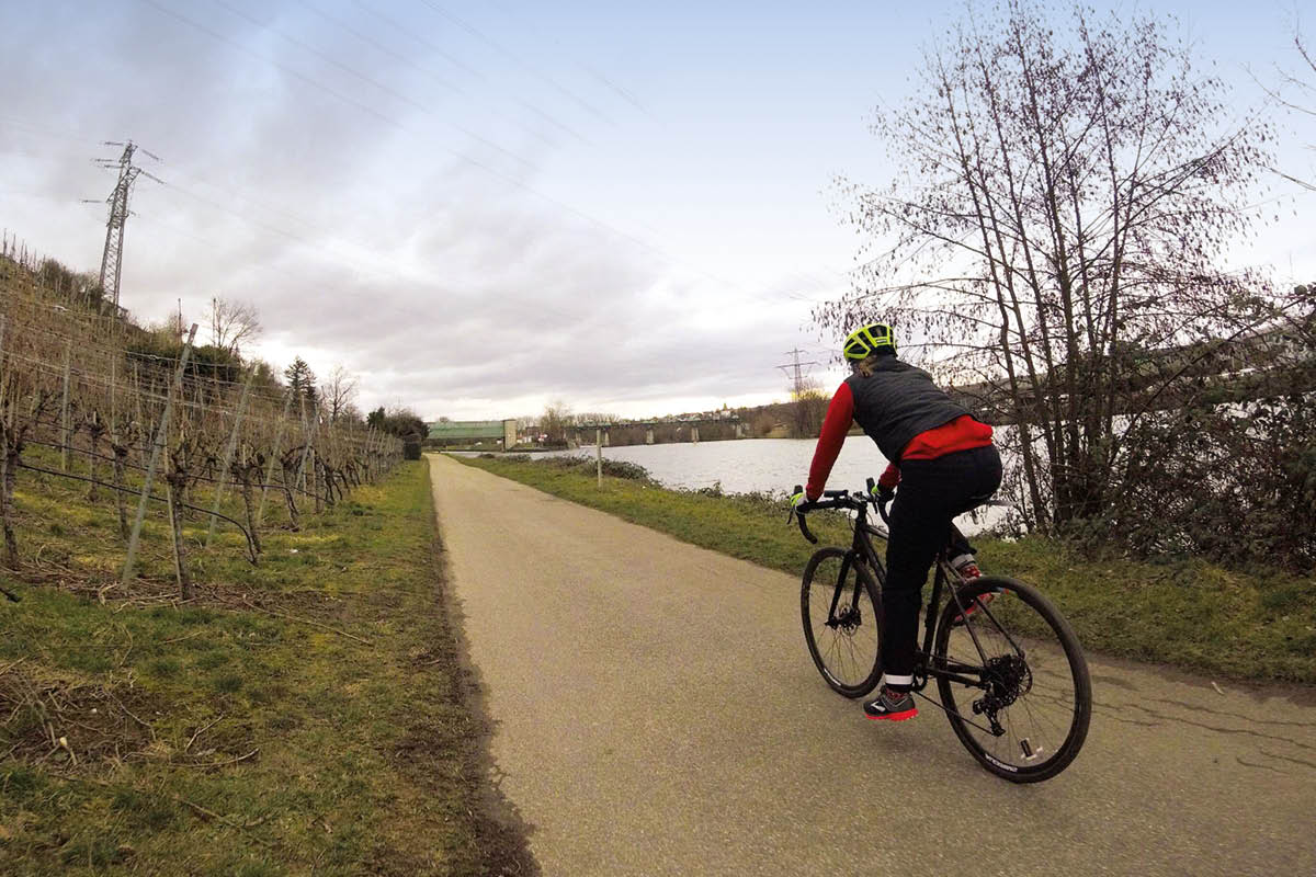 Auf dem Bild sieht man einen Radfahrerin im Gelände radfahren.