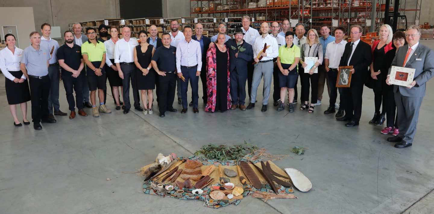 The picture shows the LAPP Australia team with Andreas and Alexander Lapp in the factory hall.