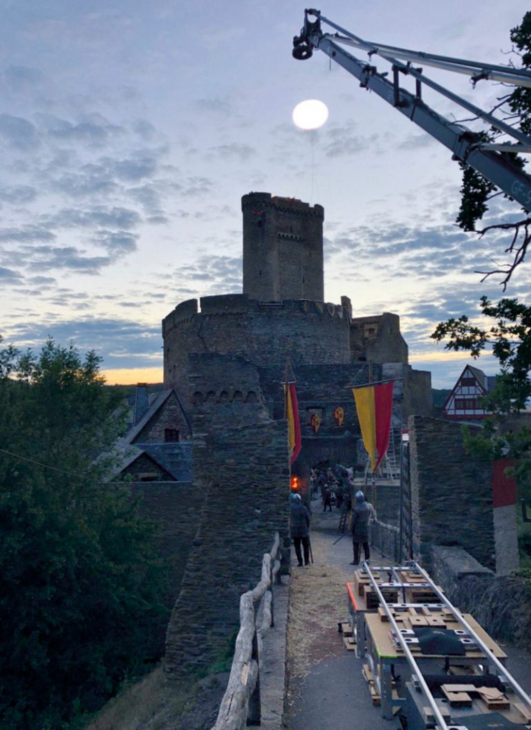 Auf dem Bild sieht man einen Lichtballons der ein nächtliches Filmset bei einer Burg ausleuchten.