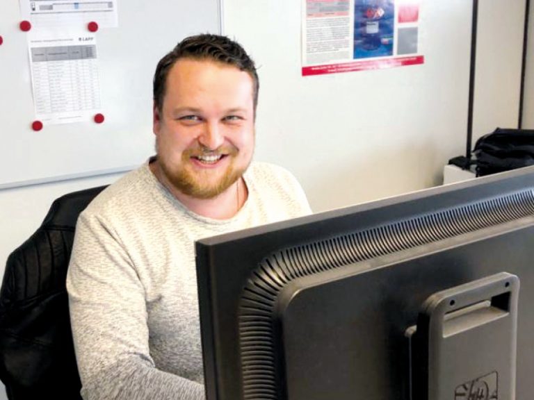 Das Bild zeigt Alexander Kraus, Mitarbeiter Materialwirtschaft Lapp GmbH Kabelwerke, bei der Arbeit vor dem Computer.