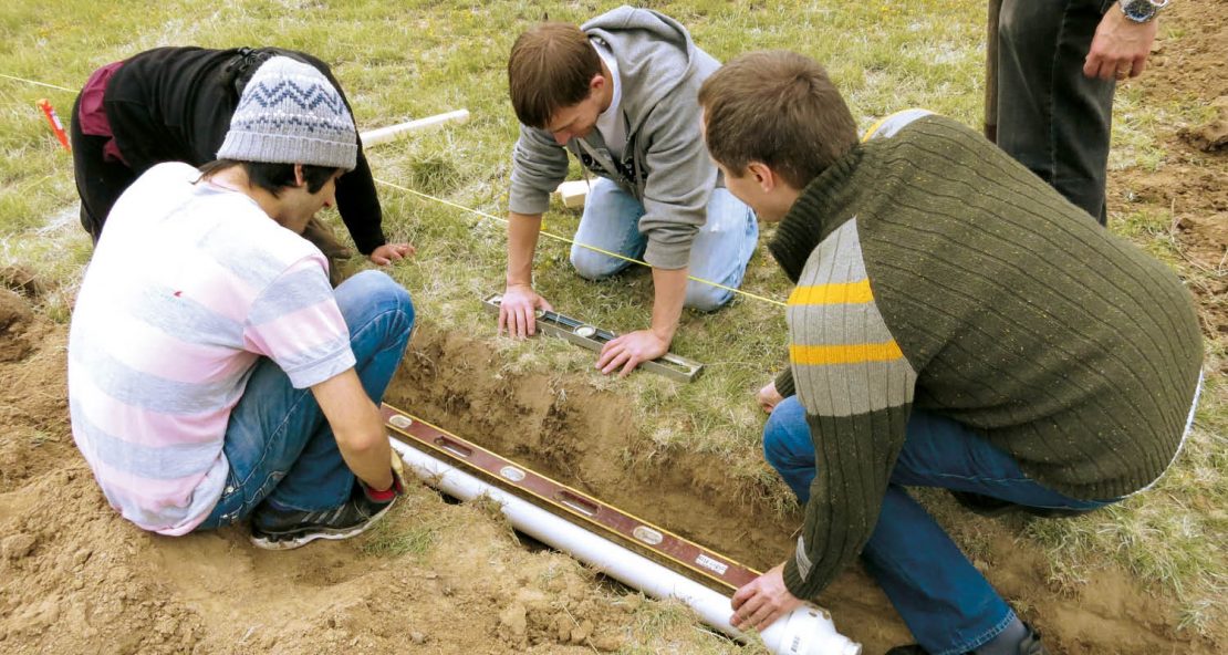 The picture shows a team of young researchers installing a sensitive antenna in the ground.