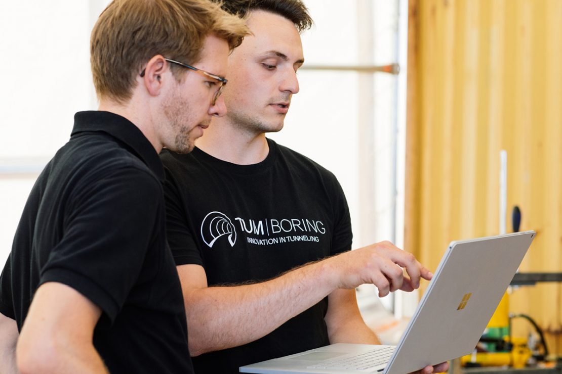 The picture shows two people in front of a laptop: Jona Roßmann, External Relations Manager at TUM Boring (right) and Patrick Olivan, LAPP Senior Business Development Manager (left).