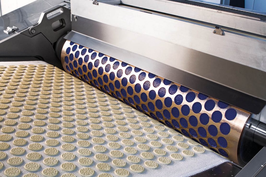 In the picture you can see how dough is formed into biscuits in biscuit production using a roller.