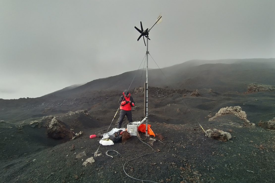 Das Bild zeigt Martin Möllhoff am Vulkan, wie der die Seismometer überprüft.