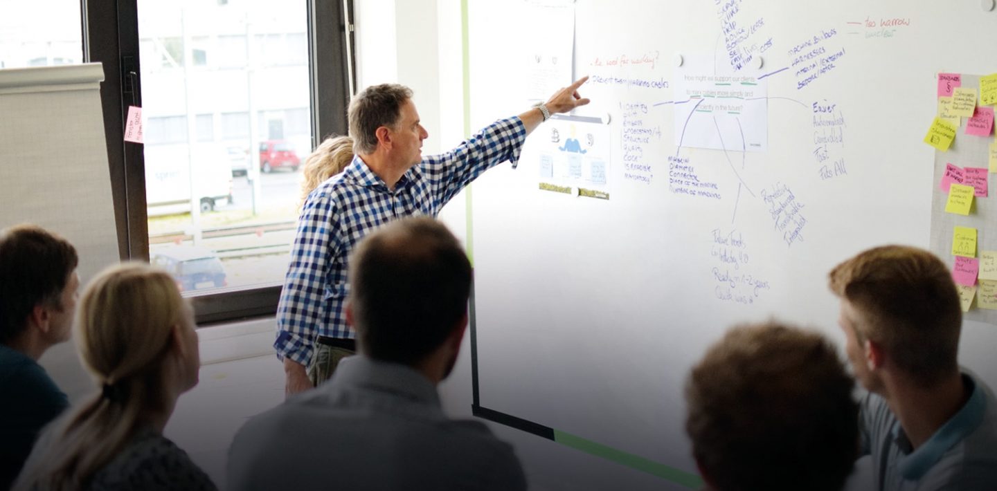 The picture shows Guido Ege, Head of Product Management and Product Development at LAPP, in a design thinking process in front of a board with graphics.