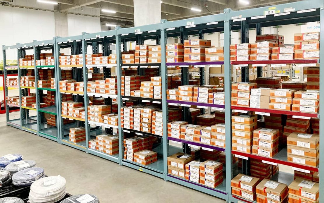 The picture shows the LAPP Japan warehouse with shelves loaded with cables and plugs.