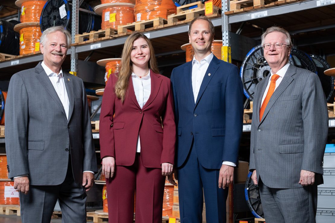The picture shows Siegbert, Katharina, Matthias and Andreas Lapp in the warehouse in front of a shelf with cables.
