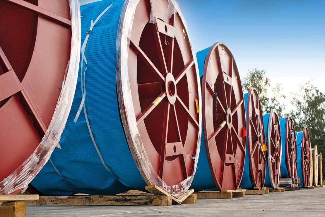 The picture shows heavy cable drums in a row.