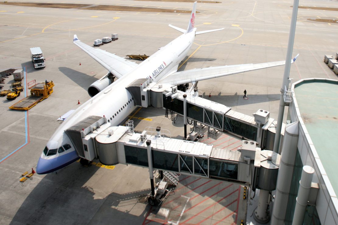 The picture shows an aircraft with two docked passenger boarding bridges from above.