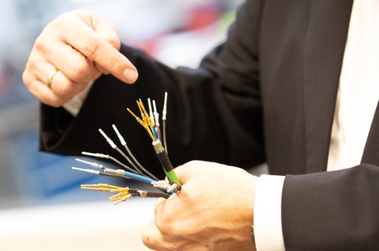 The picture shows a cable with a stripped lines in the hand of a man. This explains the components of a Lapp special management for the Scheuerle SPMT K24.