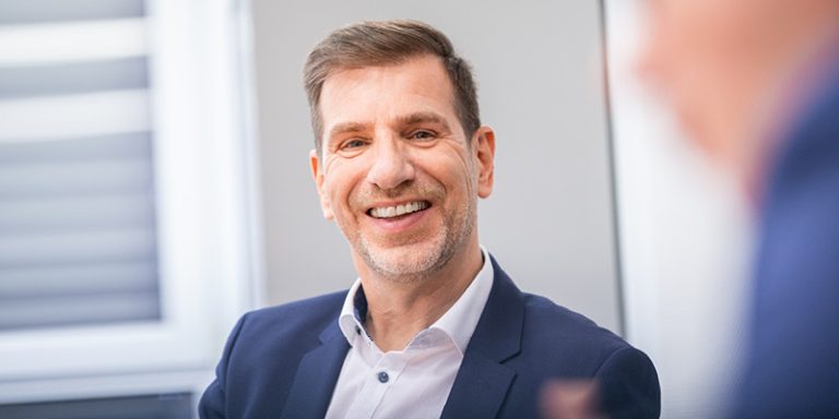 Das Bild zeigt Thorsten Grünberg – Industry Manager Train bei der U.I. LAPP GmbH im Portrait bei einer Besprechung.